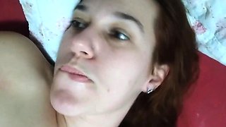 Young redhead in bed beating a syririca