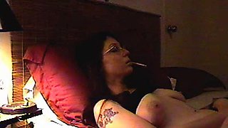 Busty big-titted brunette is smoking and masturbating