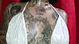 Tattooed Latin woman, black heels plays modeling